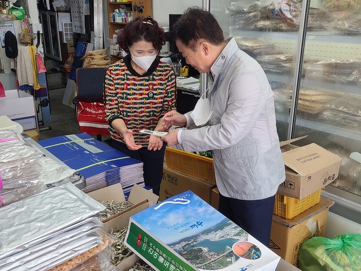 정기명 여수시장이 7일 전통시장을 찾아 여수시민게 지급된 일상회복지원금으로 건어물을 사고 있다. 여수시 제공 *재판매 및 DB 금지