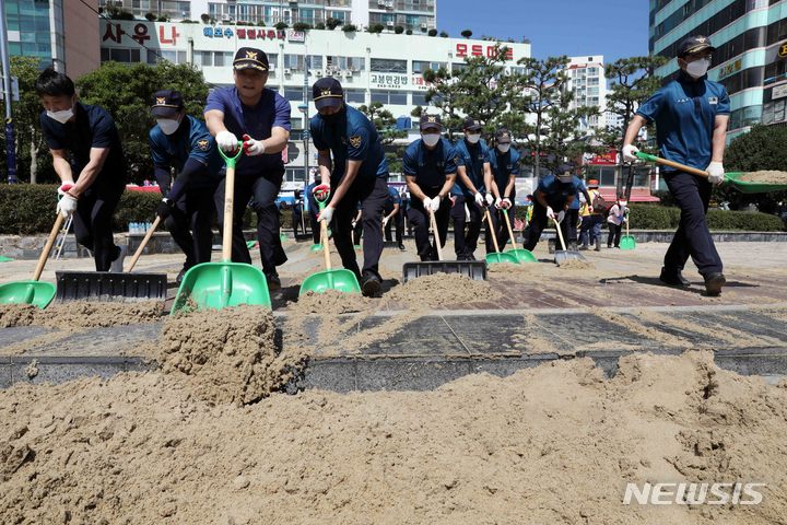 [부산=뉴시스] 하경민 기자 = 제11호 태풍 '힌남노'의 영향으로 부산 곳곳에서 피해가 발생한 가운데 7일 오전 서구 송도해수욕장 해변에서 경찰관들이 해일로 인해 인도를 뒤덮은 모래를 치우고 있다. 2022.09.07. yulnetphoto@newsis.com