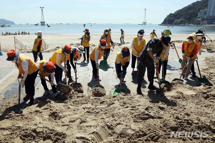 [부산=뉴시스] 하경민 기자 = 제11호 태풍 '힌남노'의 영향으로 부산 곳곳에서 피해가 발생한 가운데 7일 오전 서구 송도해수욕장 해변에서 적십자 자원봉사원과 군 및 경찰 장병 등이 해일로 인해 인도를 뒤덮은 모래를 치우고 있다. 2022.09.07. yulnetphoto@newsis.com