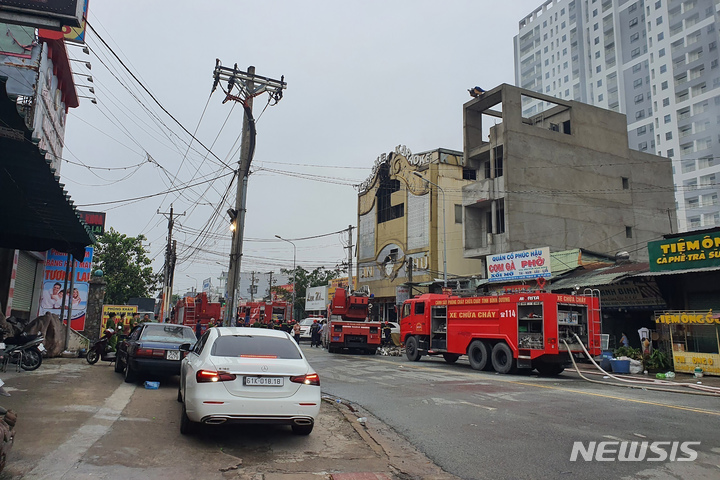 [투안(베트남)=AP/뉴시스]7일 베트남 남부 빈즈엉성 투안에서 소방차들이 하루 전인 6일 밤(현지시간) 화재가 발생한 노래방 앞에 줄지어 서 있다. 이 화재로 최소 14명이 사망하고 40명이 부상했다. 2022.9.7