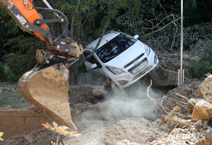 [포항=뉴시스] 고범준 기자 = 8일 오전 경북 포항시 북구 대흥중학교 뒤편 야산에서 관계자들이 태풍 '힌남노' 영향으로 발생한 산사태 현장 복구작업을 하고 있는 가운데 한 차량이 위태롭게 보이고 있다. 2022.09.08. bjko@newsis.com