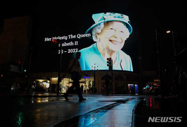 [런던=AP/뉴시스] 8일(현지시간) 영국 런던의 피커딜리 서커스 대형 스크린에 엘리자베스 2세 여왕의 사진이 투영되고 있다. 엘리자베스 2세 영국 여왕이 즉위 70년 만에 96세 나이로 서거했다. 2022.09.09.