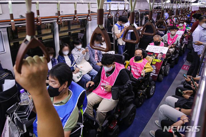 [서울=뉴시스] 권창회 기자 = 전국장애인차별철폐연대(전장연) 회원들이 지난 13일 오전 서울 용산구 삼각지역에서 열린 '제36차 출근길 지하철 탑니다' 기자회견을 마친 뒤 지하철에 탑승하고 있다. 2022.09.13. kch0523@newsis.com