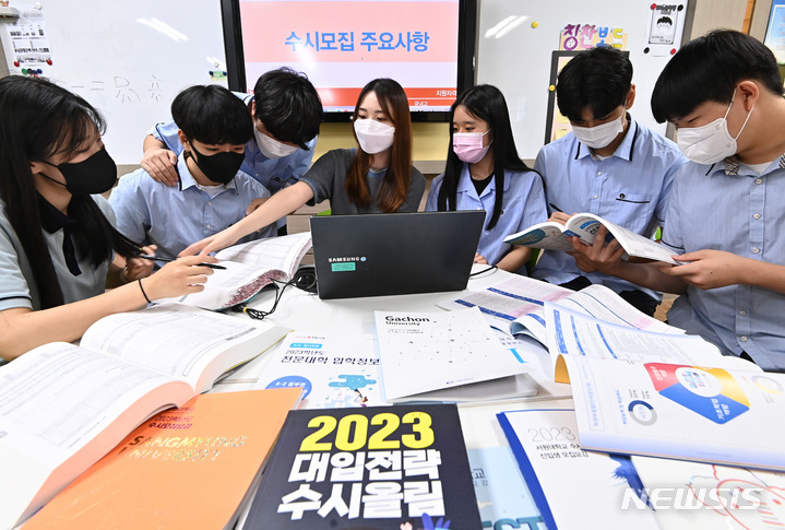[수원=뉴시스] 김종택기자 = 2023학년도 수시모집 원서접수가 시작된 지난 13일 오후 경기도 수원시 조원고등학교에서 고3 학생들이 선생님과 진학자료집을 살펴보고 있다. 2022.09.13. jtk@newsis.com