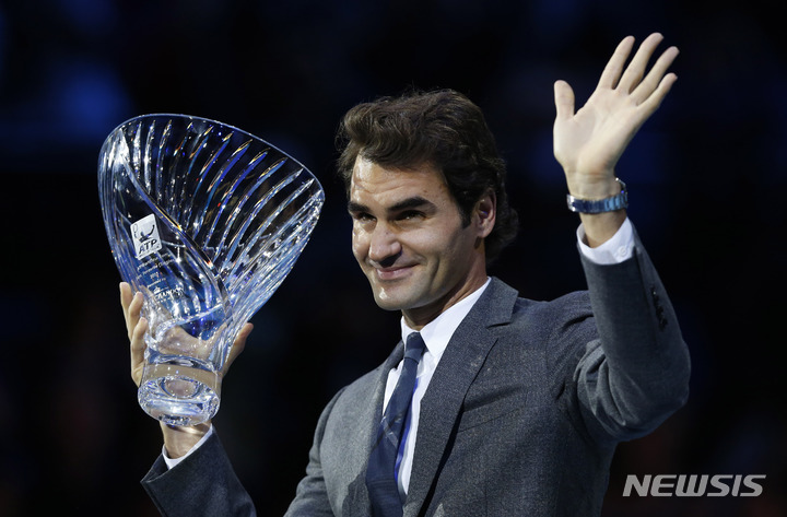[런던=AP/뉴시스] 스위스의 로저 페더러가 13년 6일 런던 O2 아레나 경기장에서 남자프로테니스(ATP) 세계 투어 결승전에서 2013년 팬들이 뽑은 '최고 인기 선수' 트로피를 들고 손을 흔들고 있다. 페더러는 15일(현지시간) 테니스계 은퇴를 발표했다. 2022.09.16.