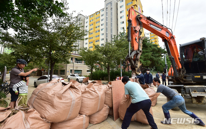 [포항=뉴시스] 이무열 기자 = 제14호 태풍 '난마돌'이 북상 중인 18일 오후 경북 포항시 남구 오천읍 부영사랑으로3차 아파트 후문에서 포항시 관계자들이 침수를 예방하기 위해 모래 제방을 쌓고 있다. 2022.09.18. lmy@newsis.com