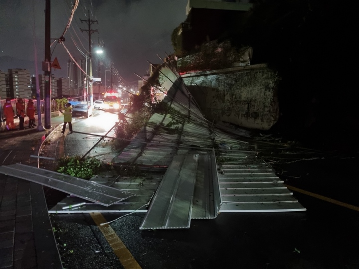 [부산=뉴시스] 태풍경보가 발효 중인 19일 오전 부산 서구의 한 길거리에서 총 50m의 철제 펜스 중 20m 구간이 강풍으로 무너졌다. (사진=부산경찰청 제공) 2022.09.19. photo@newsis.com *재판매 및 DB 금지