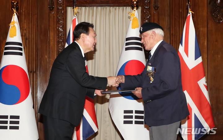 [런던=뉴시스] 홍효식 기자 = 윤석열 대통령이 19일(현지시간) 런던 한 호텔에서 열린 한국전 참전용사 국민포장 수여식에서 빅터 스위프트 영국 한국전참전용사협회 회장에게 국민포장을 수여하며 악수하고 있다. 2022.09.19. yesphoto@newsis.com