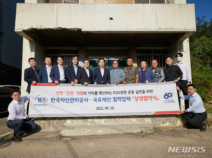 [서울=뉴시스] 홍영 캠코 국유재산본부장(뒷줄 왼쪽 여섯번째)과 국유재산 개·보수 공사 협력사 관계자들이 20일 서울 강서구 국유건물 해체 공사 현장에서 열린 'ESG경영 전략 실천을 위한 상생협약식'에서 기념촬영을 하고 있다. 2022.9.20. (사진= 한국자산관리공사 제공) photo@newsis.com