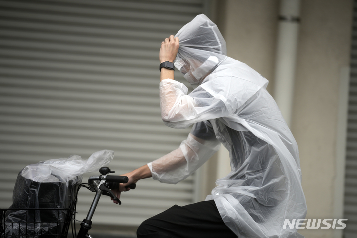 [가와사키=AP/뉴시스] 20일 일본 도쿄 인근 가와사키에서 비옷을 입은 시민이 제14호 태풍 '난마돌'의 영향으로 불어오는 강풍과 비를 뚫고 자전거로 다리를 건너고 있다. 난마돌의 영향으로 19일까지 사망자 2명 부상자 82명이 확인됐다. 2022.09.20.