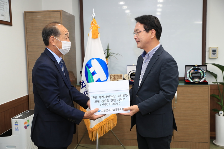 고창군수협 김충 조합장(왼쪽)이 '갯벌 세계자연유산보전본부'의 고창 유치를 희망하는 어민들의 뜻을 모아 서명부를 작성, 심덕섭 고창군수(오른쪽)에게 전달하고 있다. *재판매 및 DB 금지