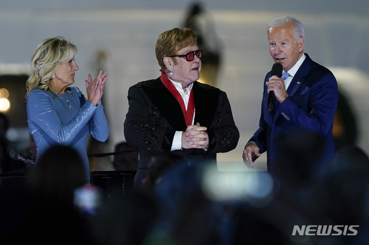 [워싱턴=AP/뉴시스] 조 바이든 미국 대통령이 23일(현지시간) 워싱턴DC 백악관에서 영국 가수 엘튼 존(75)에게 '국가인문학' 훈장을 수여하고 발언하고 있다. 2022.09.24