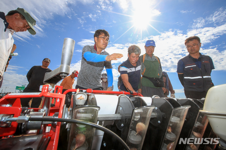 [서귀포=뉴시스] 우장호 기자 = 26일 오전 제주 서귀포시 대정읍 신도리의 한 농지에서 마늘농가와 대정농협, 서부농업기술센터 관계자들이 참석한 가운데 마늘 파종 인력난 해소를 위한 파종기 시연이 진행되고 있다. 2022.09.26. woo1223@newsis.com