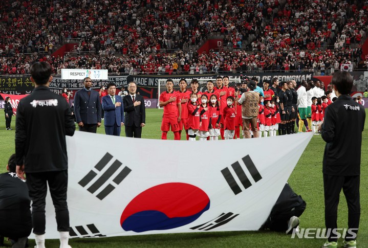 [서울=뉴시스] 백동현 기자 = 27일 오후 서울 마포구 서울월드컵경기장에서 열린 하나은행 초청 축구 국가대표 평가전 대한민국과 카메룬의 경기, 선발 출전한 선수들이 국기에 대한 경례하고 있다. 2022.09.27. livertrent@newsis.com