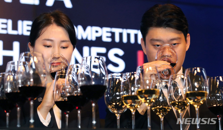 [서울=뉴시스] 김진아 기자 = 30일 서울 종로구 JW 메리어트 동대문 스퀘어 서울에서 열린 '제21회 한국 소믈리에 대회' 결선에 앞서 결선진출자인 한희수(롯데백화점), 김민준(정식당) 소믈리에가 향을 음미하고 있다. 2022.09.30. bluesoda@newsis.com