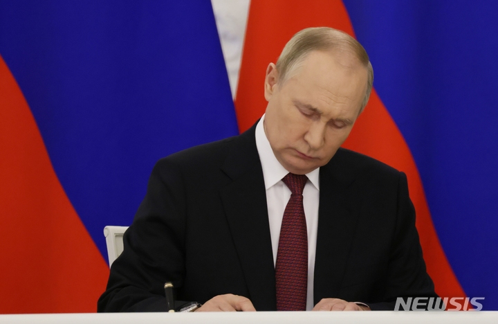 [모스크바=AP/뉴시스} 라디미르 푸틴 러시아 대통령이 18일 북한 국빈방문을 앞두고 북한과의 포괄적 전략동반자협정 초안을 승인했다. 사진은 푸틴 대통령이 2022년 9월30일 크렘린궁에서 열린 서명식에서 서명하는 모습. 2024.06.18 
