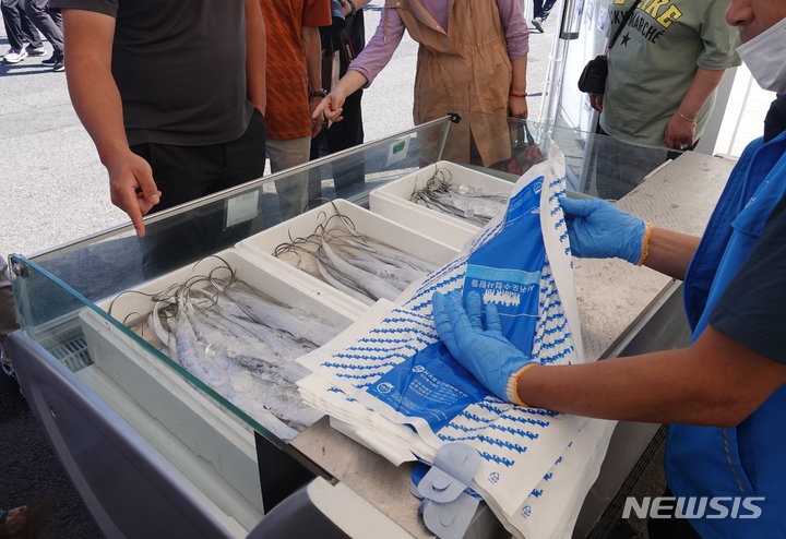 [서귀포=뉴시스] 서귀포 은갈치 축제가 열리는 제주 서귀포시 서귀포항 동부두에서 은갈치 할인 매장을 찾은 방문객들이 은갈치를 구매하고 있다. (사진=뉴시스 DB). photo@newsis.com 
