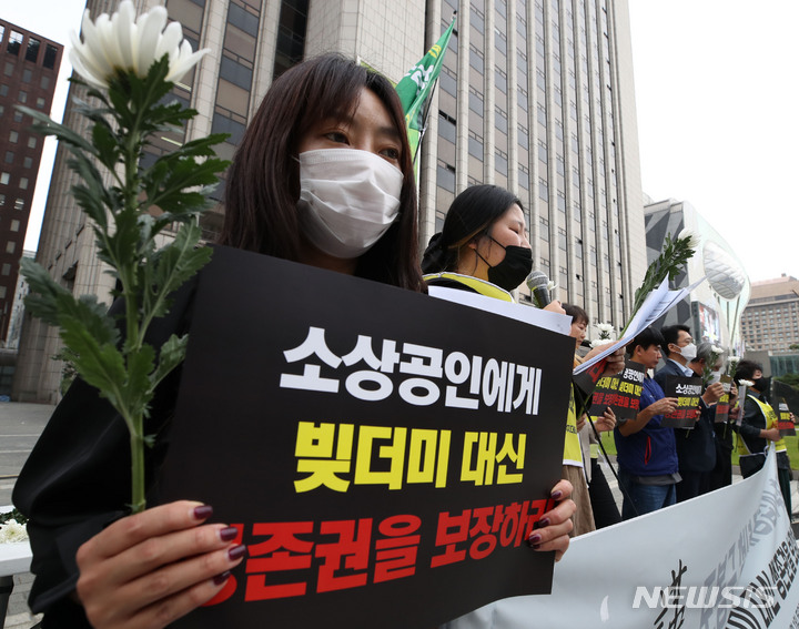 [서울=뉴시스] 조수정 기자 = 소상공연합회 등 단체가 1일 오후 서울 중구 프레스센터 앞에서 '빚더미 대신 생존권을 보장하라' 도봉구 청년 자영업자 추모제 및 기자회견을 하고 있다. 이들은 시장에서 자영업을 하던 20대 청년이 6개월 동안 임대료를 내지 못하고 생활고에 시달리다가 지난 24일 서울 도봉구 아파트에서 숨진 채 발견된 사건과 관련, 고인을 추모하는 국화 꽃을 들고 기자회견을 진행했다. 회견에서 대선 전후 대통령이 공약한 손실보전금을 약속대로 지원해야 한다고 촉구했다. 2022.10.01. chocrystal@newsis.com