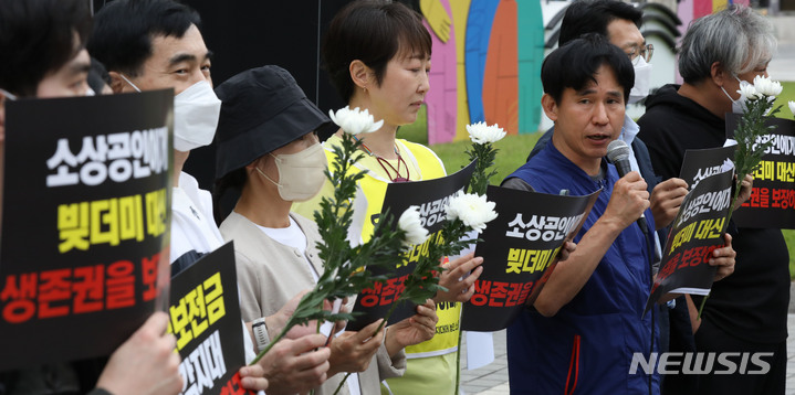 [서울=뉴시스] 조수정 기자 = 소상공연합회 등 단체가 1일 오후 서울 중구 프레스센터 앞에서 '빚더미 대신 생존권을 보장하라' 도봉구 청년 자영업자 추모제 및 기자회견을 하고 있다. 이들은 시장에서 자영업을 하던 20대 청년이 6개월 동안 임대료를 내지 못하고 생활고에 시달리다가 지난 24일 서울 도봉구 아파트에서 숨진 채 발견된 사건과 관련, 고인을 추모하는 국화 꽃을 들고 기자회견을 진행했다. 회견에서 대선 전후 대통령이 공약한 손실보전금을 약속대로 지원해야 한다고 촉구했다. 2022.10.01. chocrystal@newsis.com