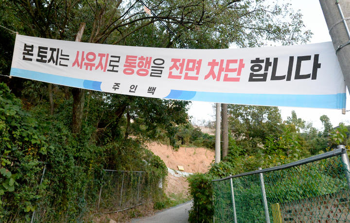 [광주=뉴시스] 김혜인 기자 = 30일 오후 광주 남구 봉선동과 동구 용산동을 잇는 통행로 입구에 '사유지 통행 금지' 현수막이 붙어있다. 땅 주인이 땅 소유권을 주장하며 통행을 차단한 상태다.2022.09.30.hyein0342@newsis.com