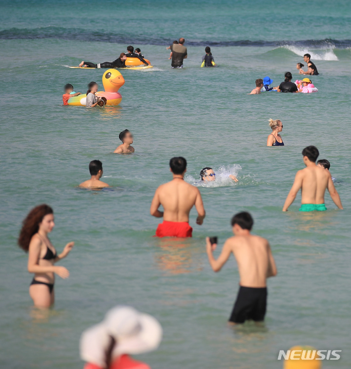 [제주=뉴시스] 우장호 기자 = 낮 최고기온이 30도에 육박하는 무더운 날씨를 보인 3일 오후 제주시 한림읍 협재해수욕장을 찾은 관광객들이 물놀이를 하며 더위를 식히고 있다. 2022.10.03. woo1223@newsis.com