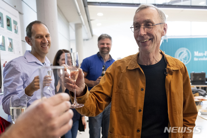 [라이프치히=AP/뉴시스] 스웨덴의 유전학자 스반테 페보 교수가 3일(현지시간) 독일 라이프치히에 있는 막스 플랑크 진화 인류학 연구소에서 동료들과 축하 샴페인을 들고 있다. 앞서 노벨상위원회는 페보 교수를 2022 노벨 생리의학상 수상자로 선정, 발표했다. 2022.10.04.