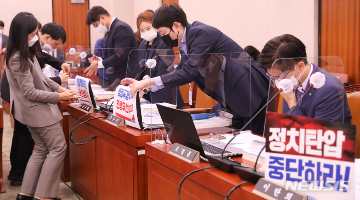 [서울=뉴시스] 전진환 기자 = 4일 서울 여의도 국회에서 열린 대법원 등에 대한 법제사법위원회 국정감사에서 더불어민주당 의원석에 '정치탄압 중단하라' 피켓을 노트북에 붙이자 국민의힘 의원석도 민생국감을 촉구하는 피켓을 붙이고 있다. (공동취재사진) 2022.10.04.  photo@newsis.com