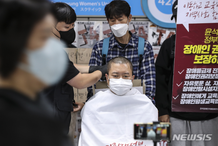 [서울=뉴시스] 김근수 기자 = 전국장애인차별철폐연대 관계자가 5일 오전 서울 지하철 4호선 삼각지역에서 장애인 권리예산과 입법을 촉구하는 삭발시위를 하고 있다. 2022.10.05. ks@newsis.com