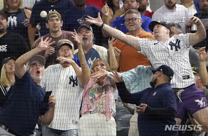[텍사스=AP/뉴시스]관중들이 애런 저지(뉴욕 양키스)의 62번째 홈런볼을 잡기 위해 손을 뻗고 있다. 2022.10.05.