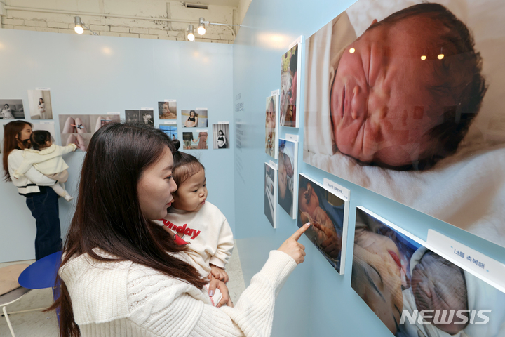 [서울=뉴시스] 조성우 기자 = 서울 성동구 압타하우스에서 열린 영유아 영양 분야 브랜드 뉴트리시아 '위 케어-1000일의 여정' 사진전을 찾은 엄마와 아이가 전시된 사진을 관람하고 있다. 2022.10.07. xconfind@newsis.com