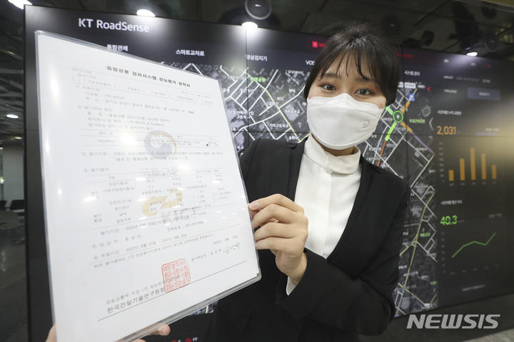 [서울=뉴시스]KT는 자체 개발한 교통디지털전환(DX) 솔루션 '로드센스(RoadSense)'가 한국건설기술연구원의 지능형교통체계(ITS) 돌발상황검지 성능평가에서 최고 등급을 받았다고 10일 밝혔다. 사진은 KT 관계자가 ‘로드센스’ 솔루션의 ITS 성능평가 성적서를 들고 기념 촬영하는 모습. (사진=KT 제공)