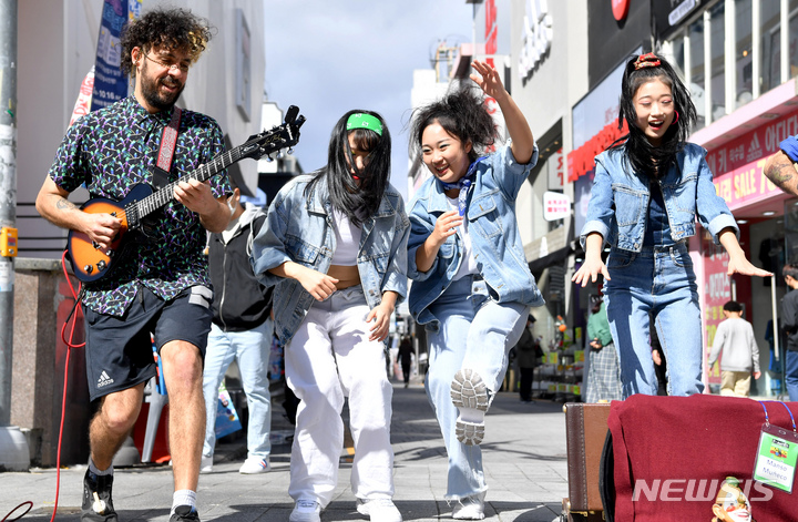 [광주=뉴시스] 이영주 기자 = 추억의 광주 충장 월드페스티벌 개막 사흘을 앞둔 10일 오전 광주 동구 충장로우체국 앞에서 아르헨티나 밴드 만조 무네코(Manso Muneco)와 충장 축제 홍보 댄스 팀이 거리공연을 펼치고 있다. 2022.10.10. leeyj2578@newsis.com