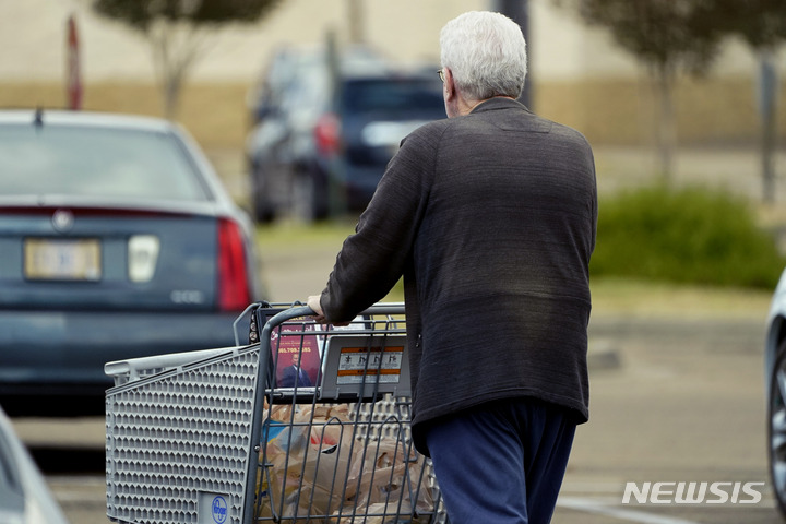An older customer pushes his Kroger shopping cart laden with purchases in Jackson, Miss., Wednesday, Oct. 12, 2022. Millions of Social Security recipients will soon learn just how high a boost they’ll get in their benefits next year. The increase will be announced Thursday morning. (AP Photo/Rogelio V. Solis)