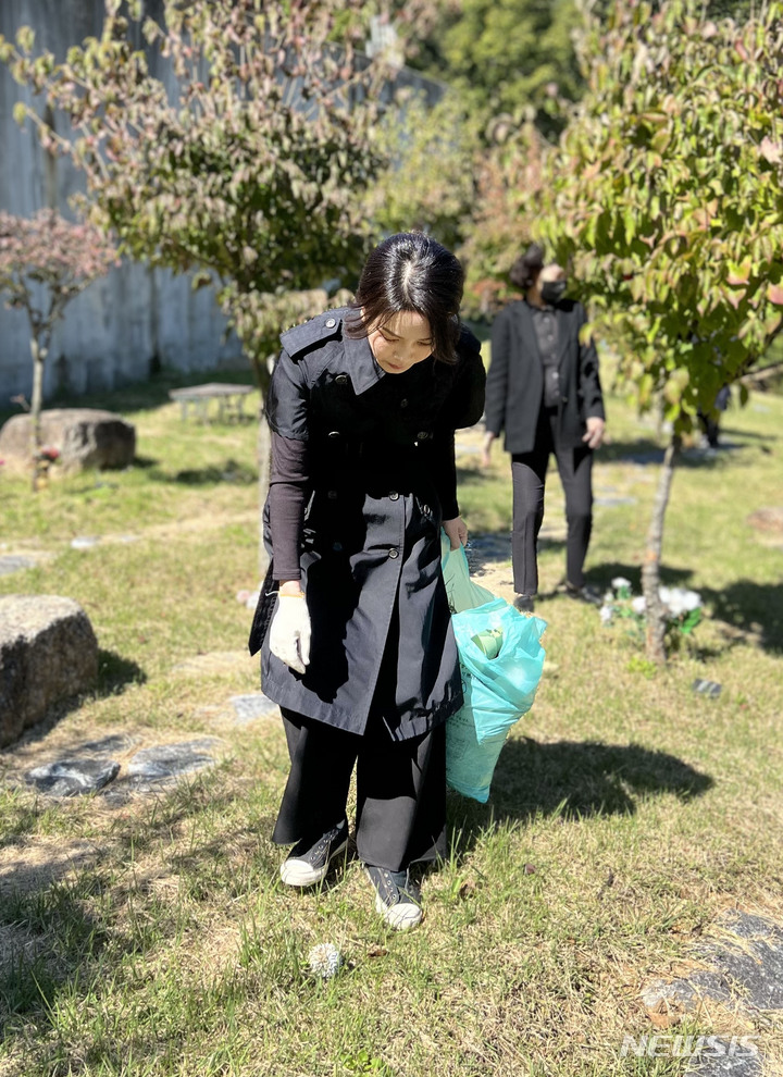 [서울=뉴시스] 윤석열 대통령 부인 김건희 여사가 '정인이 사건' 2주기를 하루 앞둔 지난 12일 경기도 양평 안데르센 메모리얼 파크를 찾아 묘역에 참배하고 주변을 정리하고 있다. (사진=대통령실 제공) 2022.10.13. photo@newsis.com