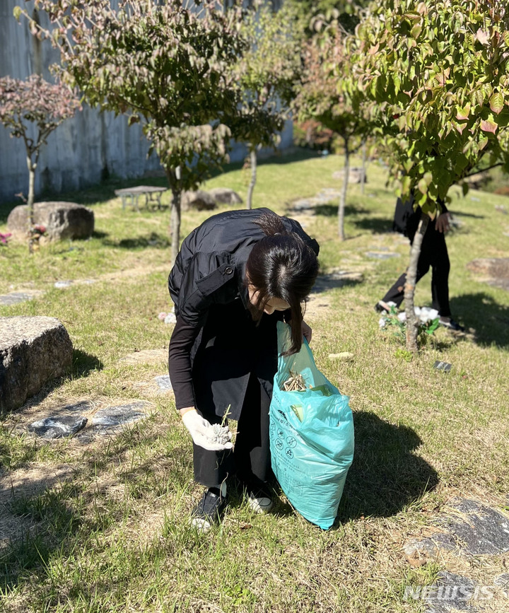 [서울=뉴시스] 윤석열 대통령 부인 김건희 여사가 '정인이 사건' 2주기를 하루 앞둔 지난 12일 경기도 양평 안데르센 메모리얼 파크를 찾아 묘역에 참배하고 주변을 정리하고 있다. (사진=대통령실 제공) 2022.10.13. photo@newsis.com