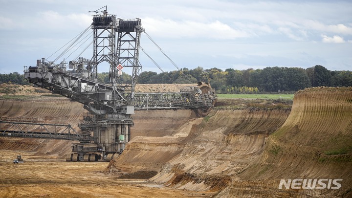 [루에체라트( 독일)= AP/뉴시스] 독일 서부의 탄광 마을 루에체레트 부근의 노천 광산에서 가르츠바일러 탄광회사가 지난 해 10월 16일 기계를 이용해 갈탄을 채굴하고 있다. 이 곳은 폐쇄될 예정이었다가 우크라이나 전쟁으로 에너지 위기에 처한 정부가 탄광을 확장하고 마을을 철거하기로 해 항의 시위가 일어나고 있다. 