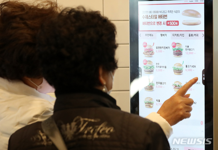 [서울=뉴시스] 이영환 기자 = 17일 오전 서울 종로구 롯데리아 동묘역점에서 어르신들이 키오스크 주문법을 배우고 있다. 서울시와 대한어머니회가 디지털 약자인 어르신들을 위해 진행한 이번 교육은 어르신들과 강사가 키오스크 사용 상점을 함께 찾아 메뉴 선택부터 결제에 이르는 전 과정을 체험해 보는 방식으로 진행됐다.2022.10.17. 20hwan@newsis.com