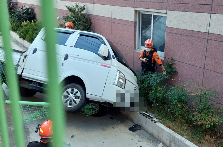 [부산=뉴시스] 펜스 들이받고 1m 아래로 추락한 화물차. (사진=부산경찰청 제공) *재판매 및 DB 금지