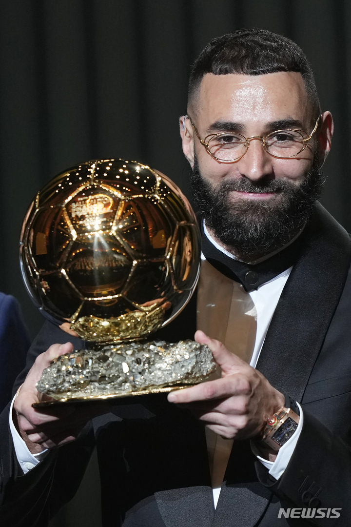 [파리=AP/뉴시스] 카림 벤제마(레알 마드리드)가 17일(현지시간) 프랑스 파리의 샤텔레 극장에서 열린 제66회 발롱도르 시상식에서 남자 발롱도르 트로피를 받고 포즈를 취하고 있다. 벤제마는 지난 시즌 라리가 32경기 27골 12도움으로 리그 득점왕, 챔피언스리그에서도 12경기 15골로 득점왕을 차지했다. 2022.10.18.