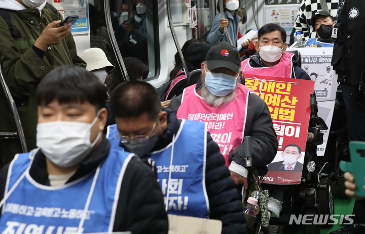 [서울=뉴시스] 김금보 기자 = 전국장애인차별철폐연대 활동가들이 19일 오전 서울 서초구 교대역 2호선 승강장에서 전동차에 탑승, '제40차 출근길 지하철 탑니다' 시위를 하고 있다. 2022.10.19. kgb@newsis.com