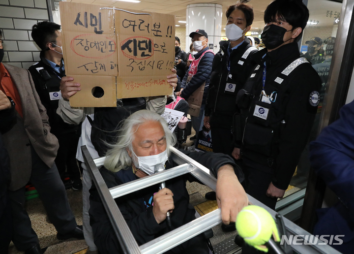 [서울=뉴시스] 김금보 기자 = 박경석 전국장애인차별철폐연대 대표가 19일 오전 서울 서초구 교대역 2호선 승강장에서 '제40차 출근길 지하철 탑니다' 시위를 하고 있다. 2022.10.19. kgb@newsis.com