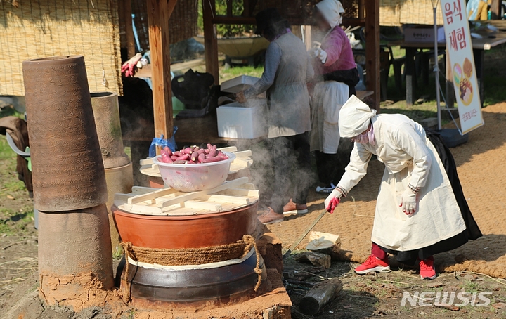 [증평=뉴시스] 강신욱 기자 = 장뜰두레농요보존회가 주최하고 증평들노래축제추진위원회가 주관한 2022 증평들노래축제가 22일 충북 증평군 증평읍 남하리 증평민속체험박물관 일대에서 개막한 가운데 전통음식체험장에서 고구마를 삶고 있다. 2022.10.22. ksw64@newsis.com