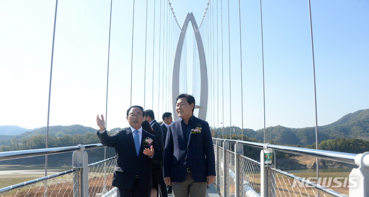 [임실=뉴시스] 김얼 기자 = 심민(왼쪽) 임실군수와 김관영 전북도지사가 22일 전북 임실군 옥정호 출렁다리에서 열린 준공식에 참석해 출렁다리를 건너며 대화를 나누고 있다. 2022.10.22. pmkeul@newsis.com
