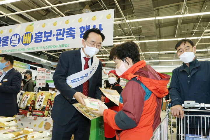 [성남=뉴시스] 윤병태 전남 나주시장이 21일 경기도 농협하나로마트 성남점에서 열린 '나주시 우수 농특산물 대도시 홍보·판촉행사'에 참석해 소비자들에게 나주햅쌀(1kg) 무료 증정 판촉 홍보 활동을 펼치고 있다. (사진=나주시 제공) 2022.10.23. photo@newsis.com *재판매 및 DB 금지