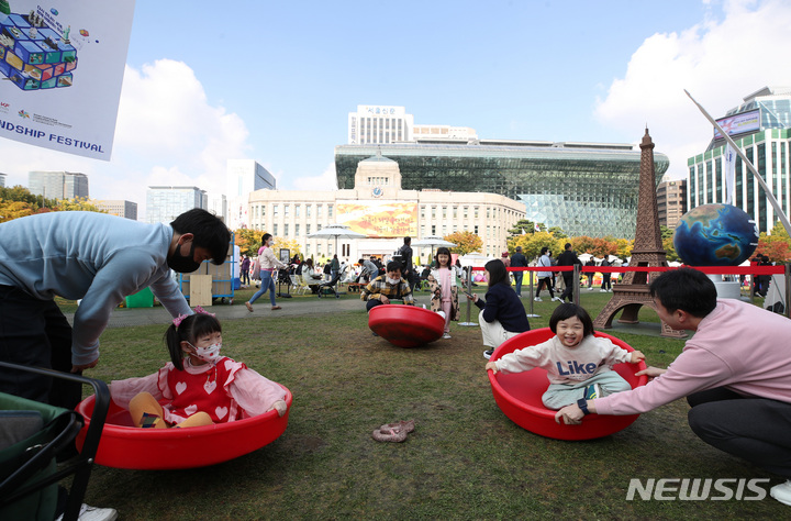 [서울=뉴시스] 김진아 기자 = 23일 오후 서울 중구 서울시청광장에서 열린 서울세계도시문화축제에 가족들이 중국의 대형 팽이 놀이를 체험하고 있다. 2022.10.23. bluesoda@newsis.com