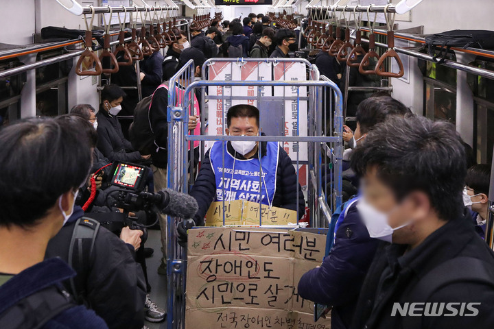 [서울=뉴시스] 권창회 기자 = 전국장애인차별철폐연대(전장연) 회원들이 지난달 25일 오전 서울 용산구 삼각지역에서 장애인권리예산 등을 촉구하는 '제41차 출근길 지하철 탑니다' 시위를 하고 있다. 2022.10.25. kch0523@newsis.com