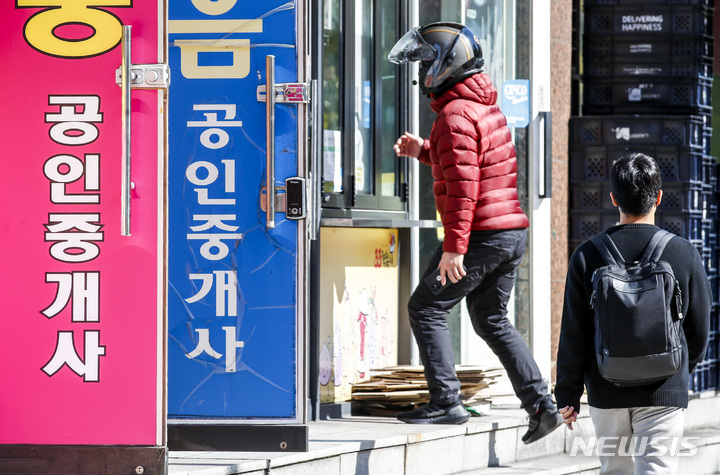 [서울=뉴시스] 정병혁 기자 = 2개월째 전국 공인중개업소 수가 감소하고 있는 것으로 나타난 25일 서울시내 공인중개업소 앞에서 시민들이 이동히고 있다. 공인중개사협회에 따르면 지난 9월 한 달 간 전국에서는 974개 업소가 폐업하고 84개 업소가 휴업한 것으로 집계됐다. 이는 한 달간 신규개업한 업소의 수인 918곳보다도 더 많은 숫자다. 이같은 전국 공인중개업소 순감 현상은 지난 2019년 11월 이후로 약 3년 만이다. 2022.10.25. jhope@newsis.com