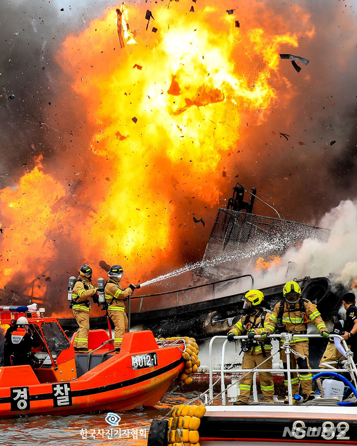 [제주=뉴시스] 뉴시스 우장호 기자가 '폭발 순간에도 꿋꿋한 당신이 있기에' 보도사진으로 한국사진기자협회 제235회 이달의 보도사진상을 수상했다. 사진은 지난해 7월7일 제주 한림항 어선 화재 당시 어선이 폭발하는 순간에도 꿋꿋이 진화 작업을 벌이는 소방대원을 포착.