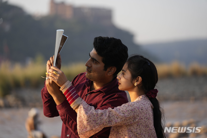 [인도=AP/뉴시스] 25일(현지시간) 인도 잠무에서 시민들이 부분일식을 보고 있다. 2022.10.26.