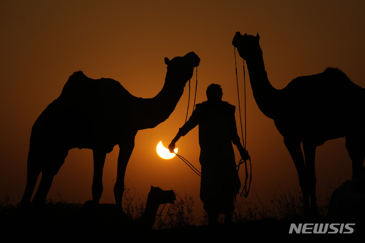 [인도=AP/뉴시스] 25일(현지시간) 인도 서부 라자스탄주의 푸슈카르에서 부분일식이 관측되고 있다. 2022.10.26.